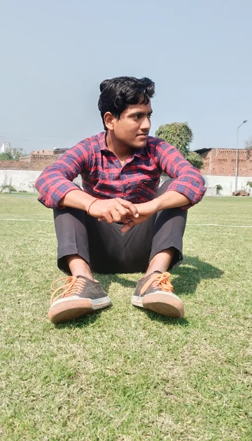 Man Sitting In The Grass With His Feet Crossed. a man sitting in the grass with his feet crossed