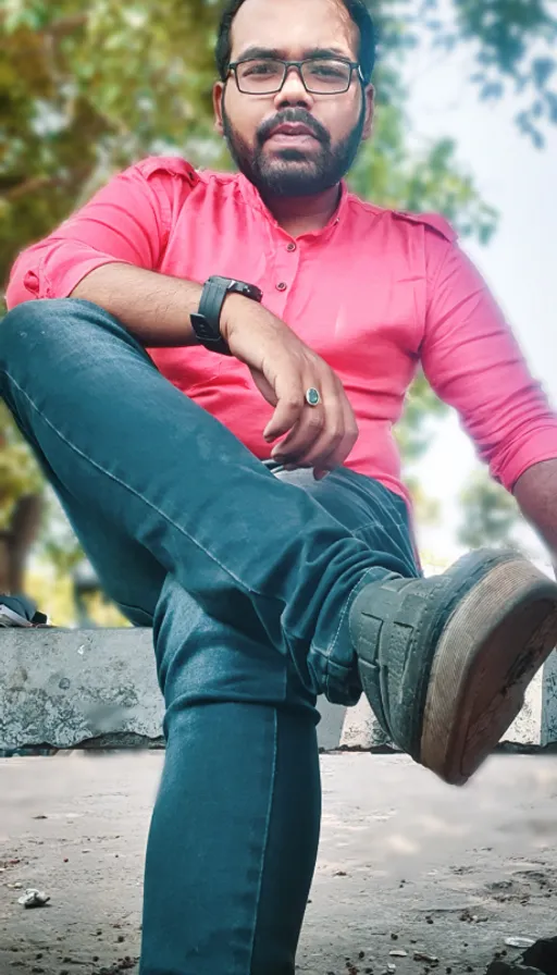 a man in a pink shirt is sitting on a bench