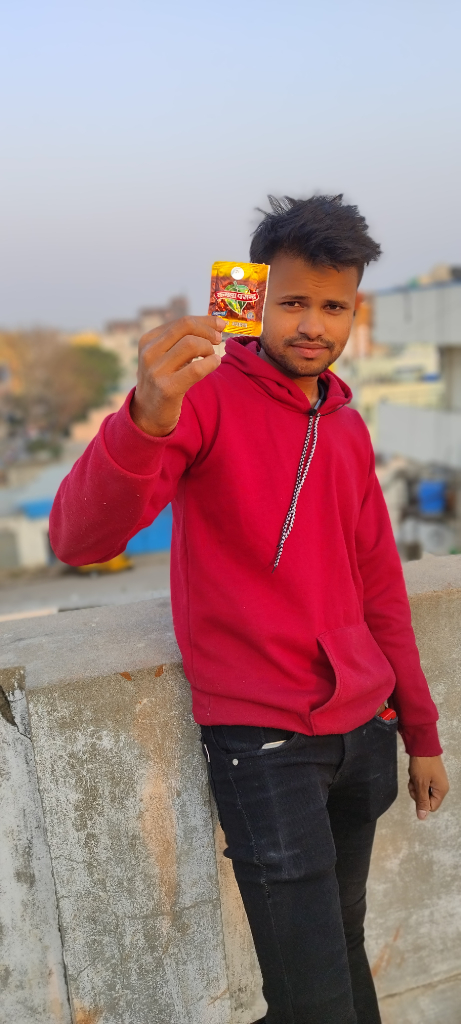 a man in a red hoodie holding up a packet of chips