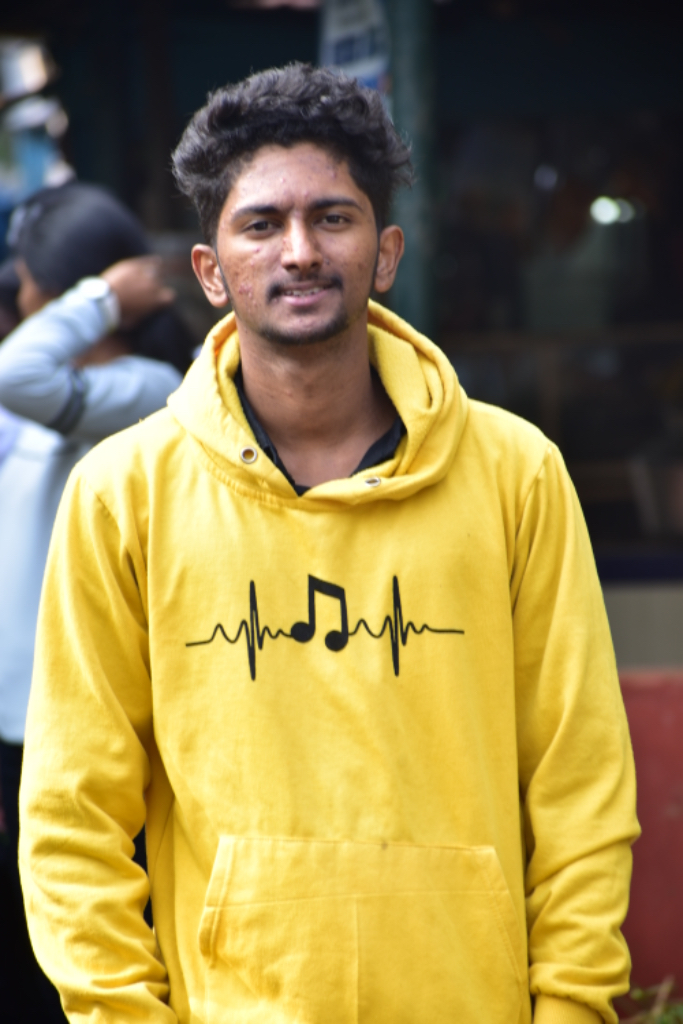 a man wearing a yellow sweatshirt with a musical note on it