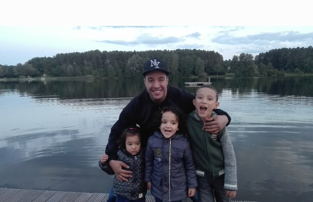 a man poses for a picture with two children