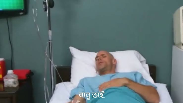 a man laying in a hospital bed next to a monitor