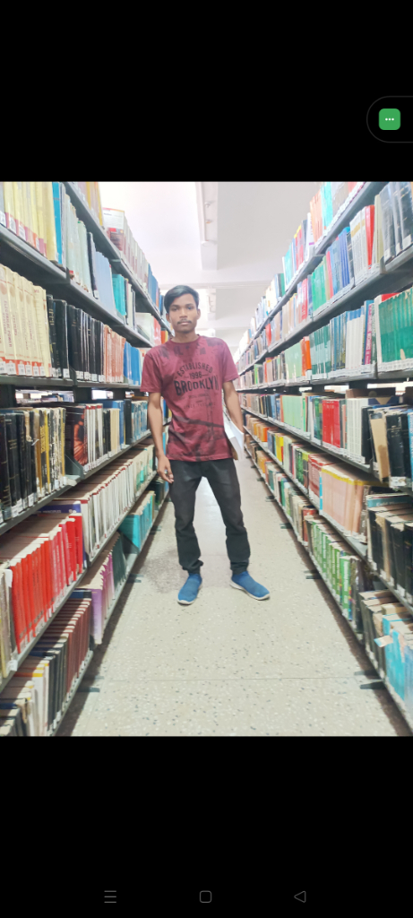 a man is standing in the aisle of a library