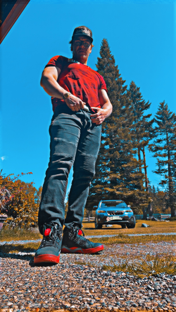 a man in a red shirt is standing on a skateboard