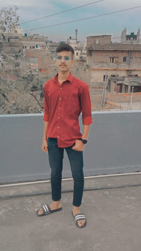 a man in a red shirt standing on a roof