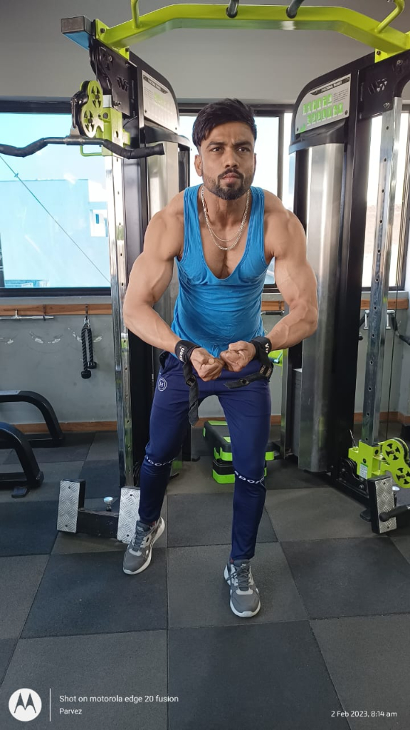 a man in a blue tank top and blue pants in a gym