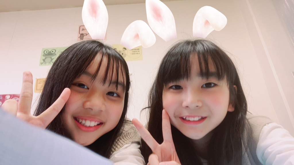 two girls with bunny ears making the peace sign