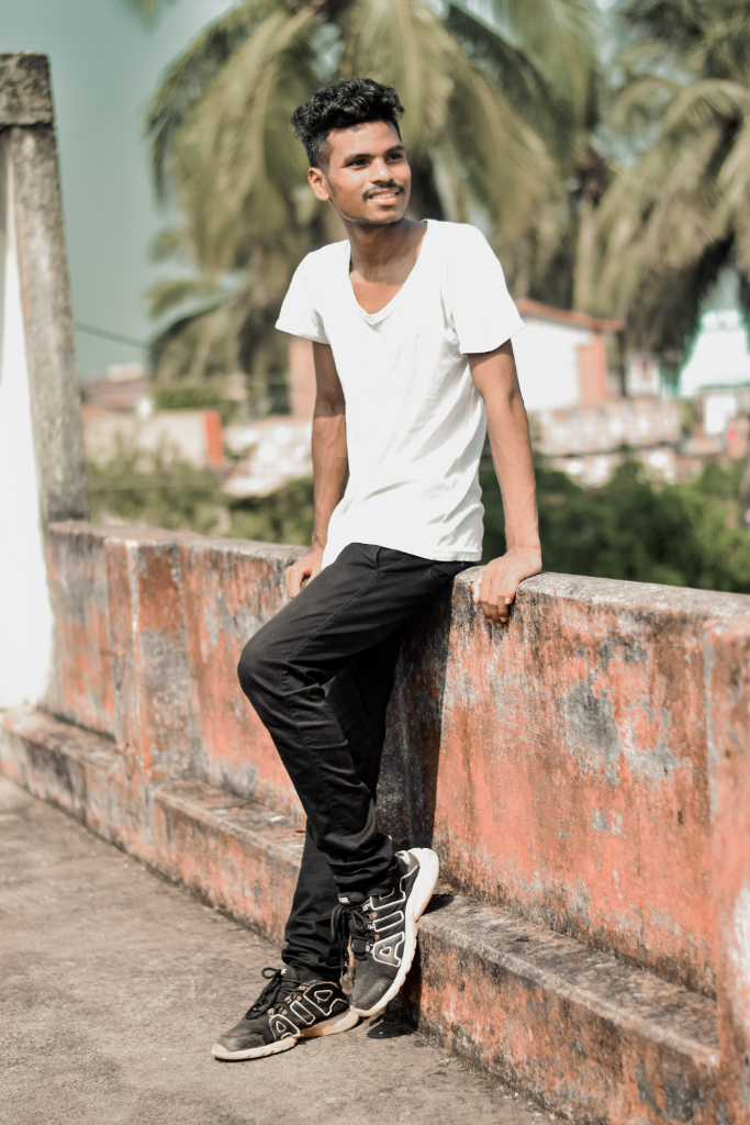 A man leaning against a wall with his foot on the wall. have him leaning against a garbage can