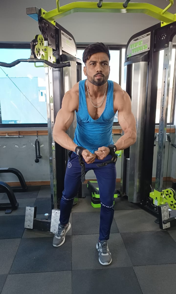 a man in a green tank top and green pants doing squats in a gym. Change the color of the pants to green, and the tank top to a yellow shirt with a green stripe running down the middle.