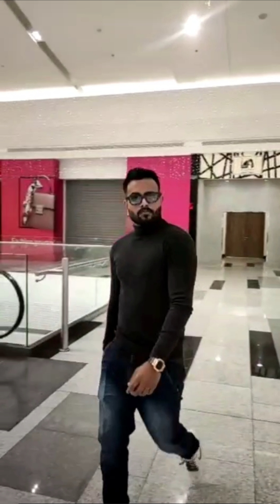 a man with a beard and glasses walking through a building