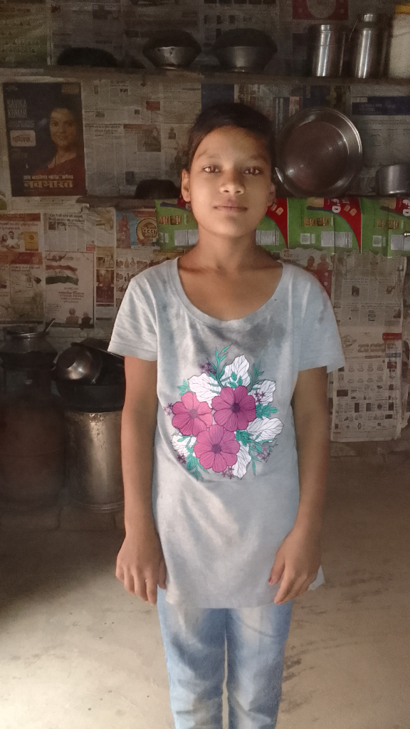 a young girl standing in a kitchen next to a stove