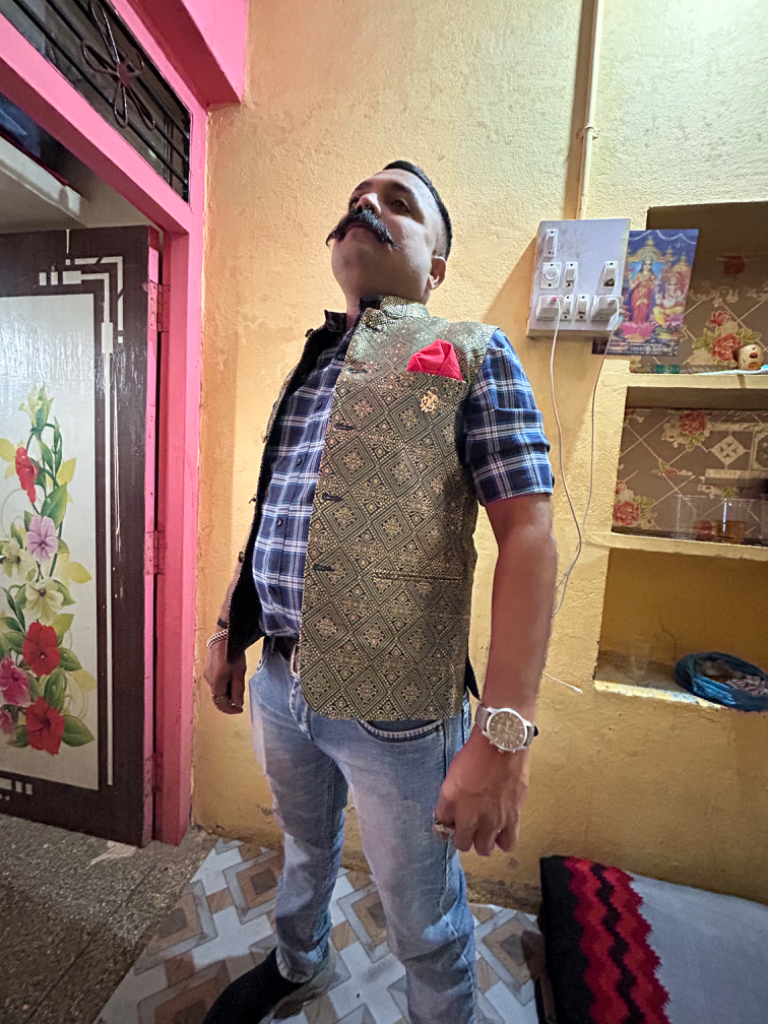 a man in a vest and bow tie standing in front of a store