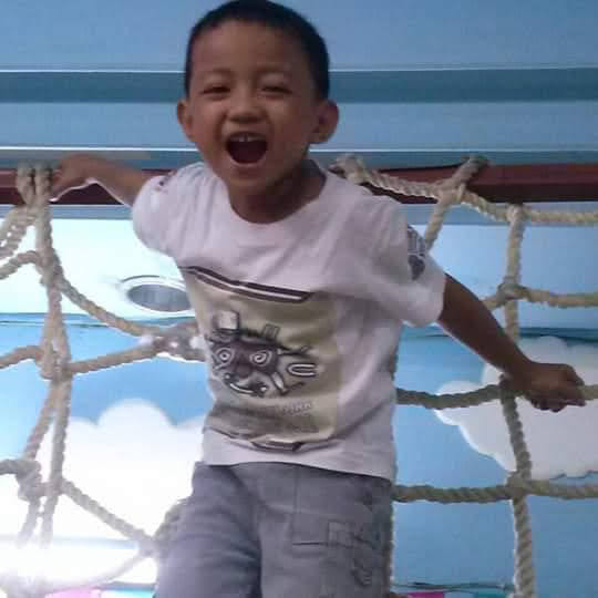 a young boy standing in a net with his mouth open