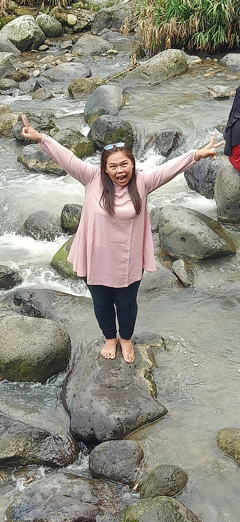 two people standing on rocks in a stream