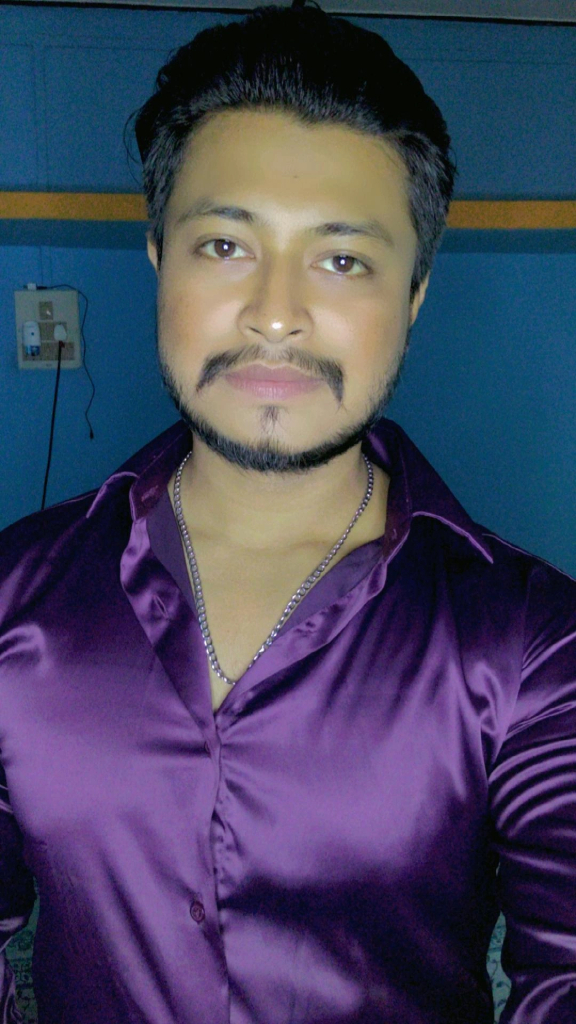 a man in a purple shirt posing for a picture