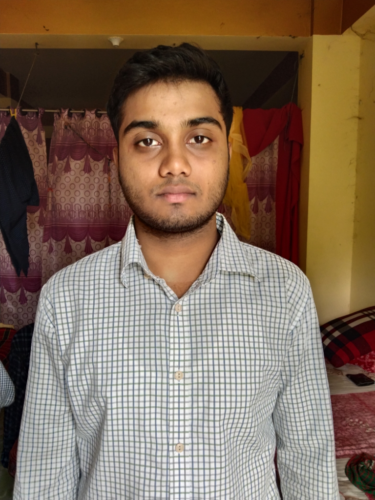 a man standing in front of a bed in a room