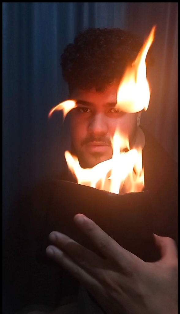 a man holding a black object with flames coming out of it