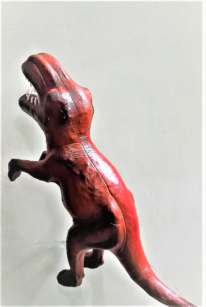 a wooden toy of a lizard on its hind legs