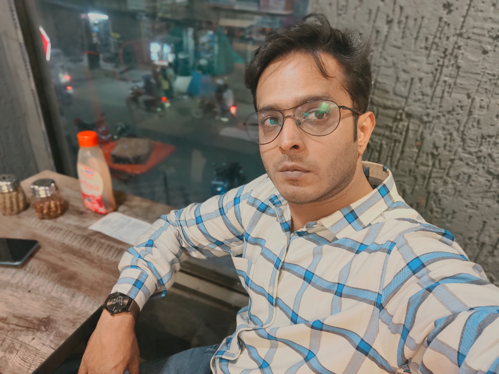 a man sitting at a table with a laptop in a natural setting. add a book, coffee mug and set in a natural setting