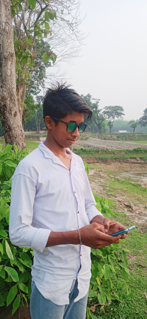 a man standing in front of a tree holding a tablet