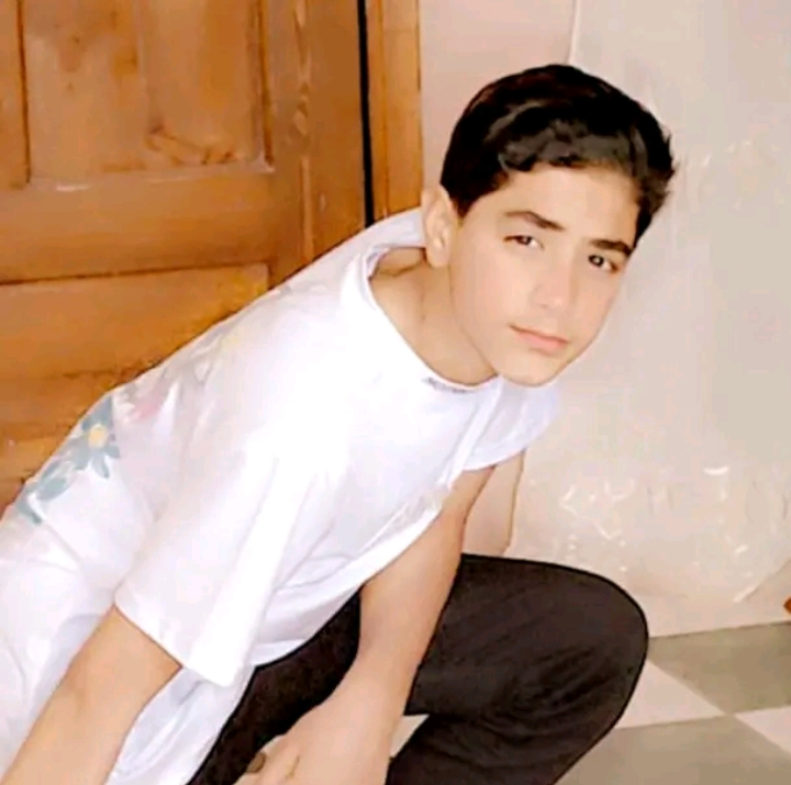 A young man squatting in front of a toilet in a charred forest. Change the backdrop to be a charred forest.