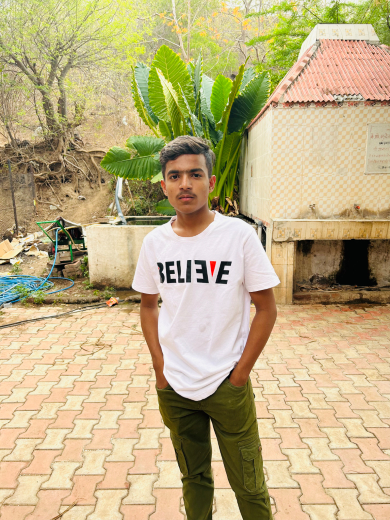 a man in a white t - shirt standing on a brick walkway