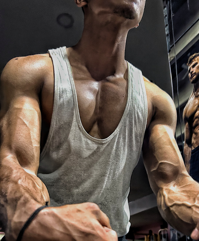 a man with a goatee standing next to another man in a gym